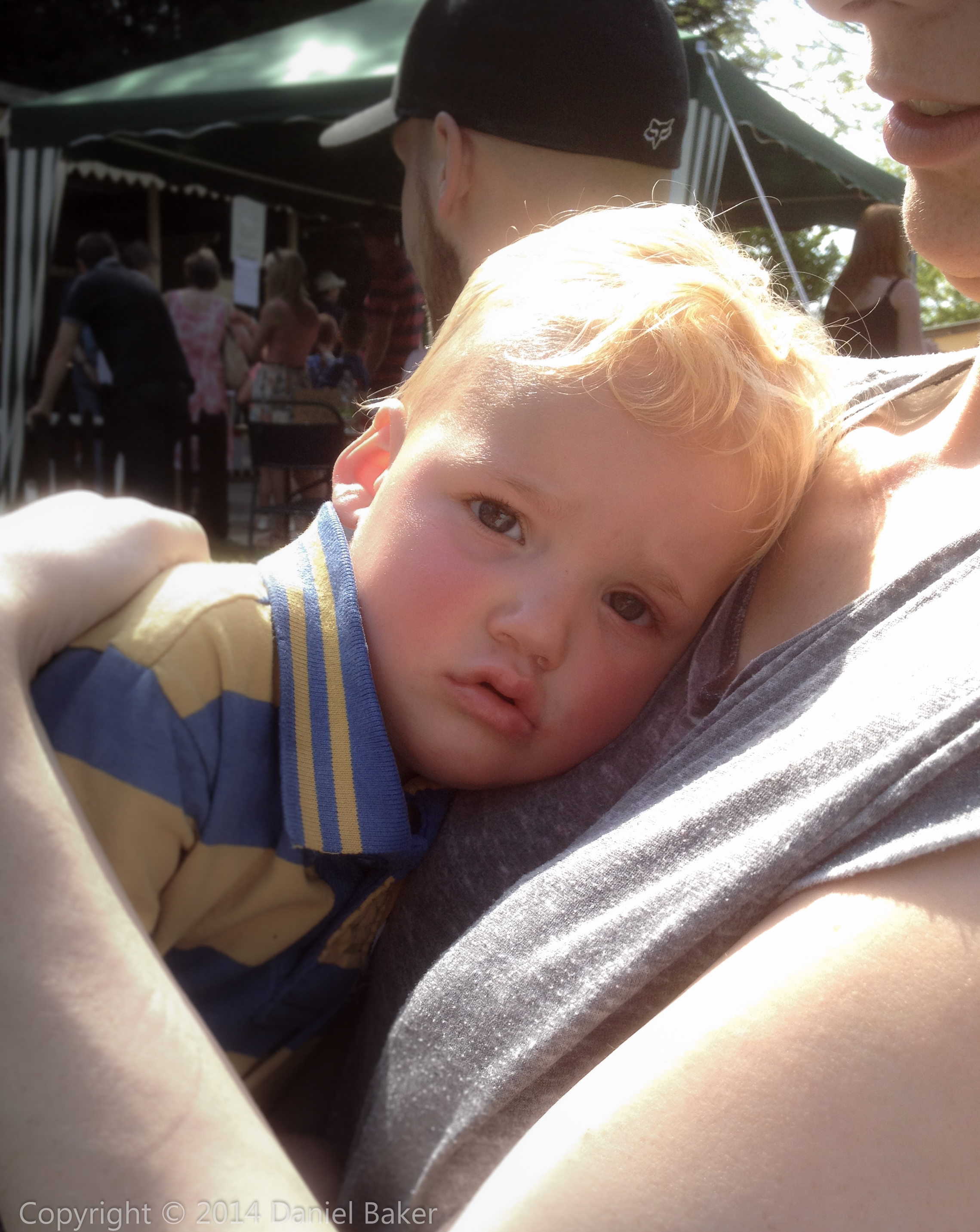 a sad looking child cuddling his Mother