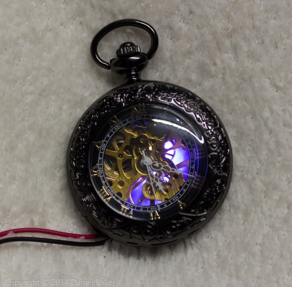 A pocket watch with a blue glow shining through for cosplay