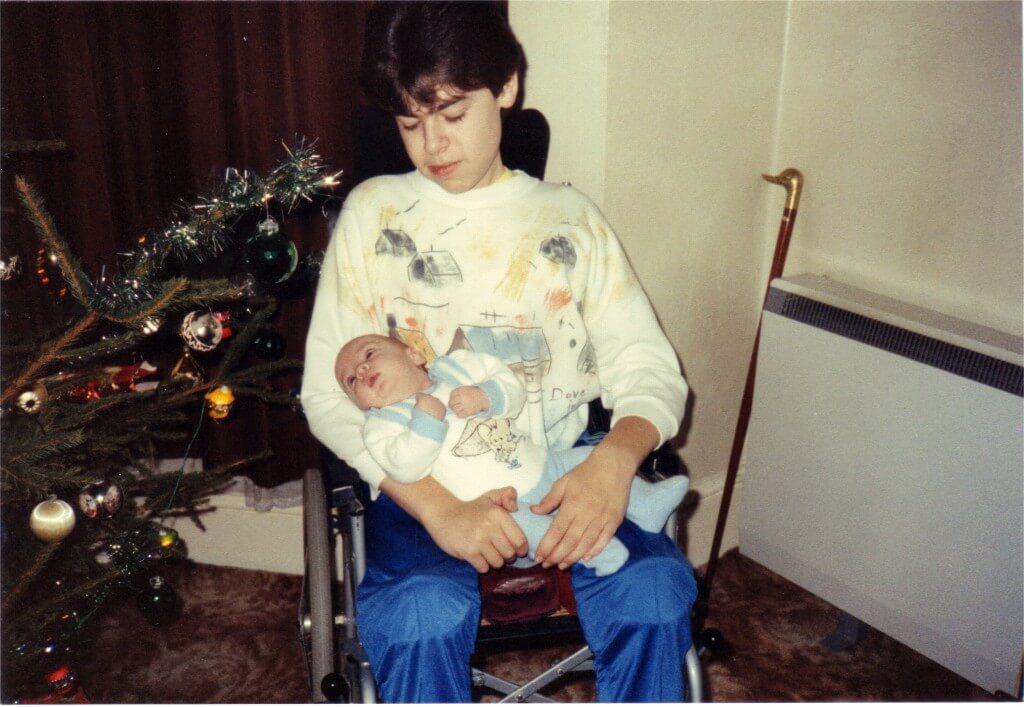 Me holding a baby in front of a Christmas tree