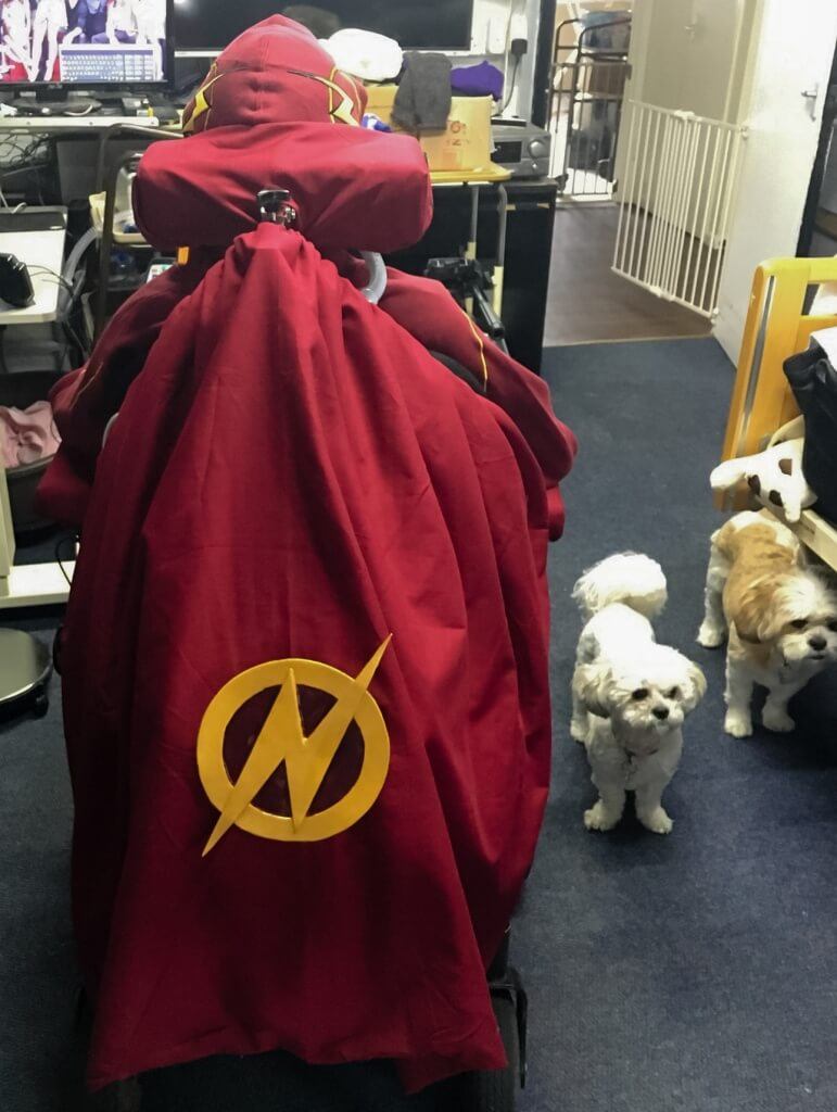 MCM London 2016 Cosplay Preview Burgundy cape with The Flash logo attached to the back of a wheelchair