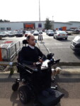 Daniel Baker outside B&Q in his wheelchair with his dog Mya
