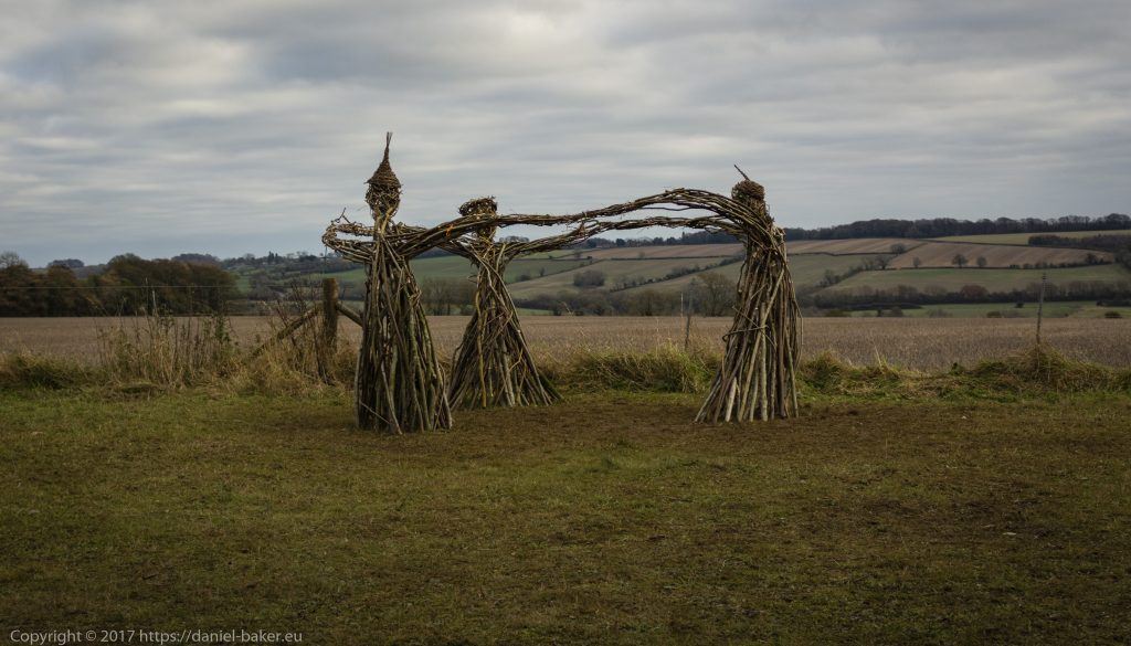 Wicker Witches standing in a circle in an English field