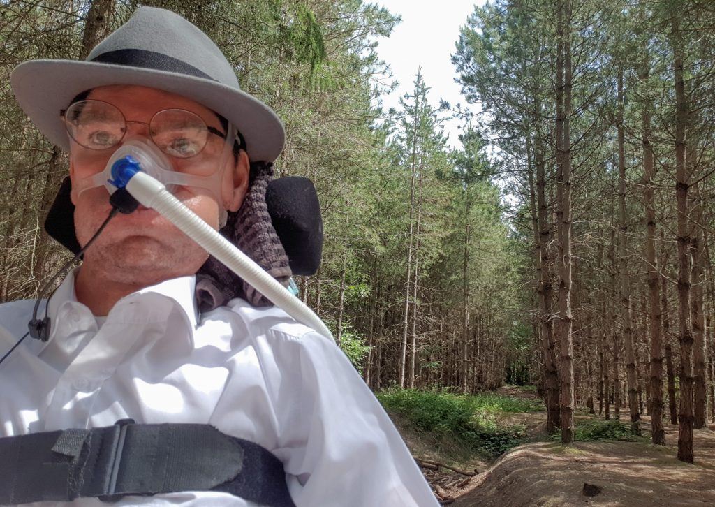 A photograph of Daniel Baker in Black Park surrounded by pine trees