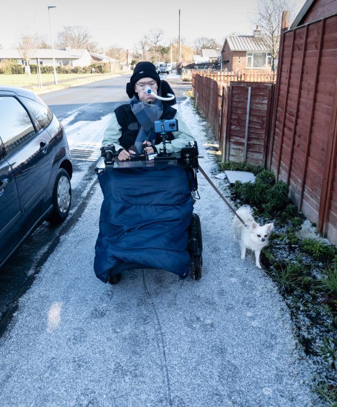 Daniel Baker walking his chihuahua Peppa along a path covered in a light sprinkling of snow