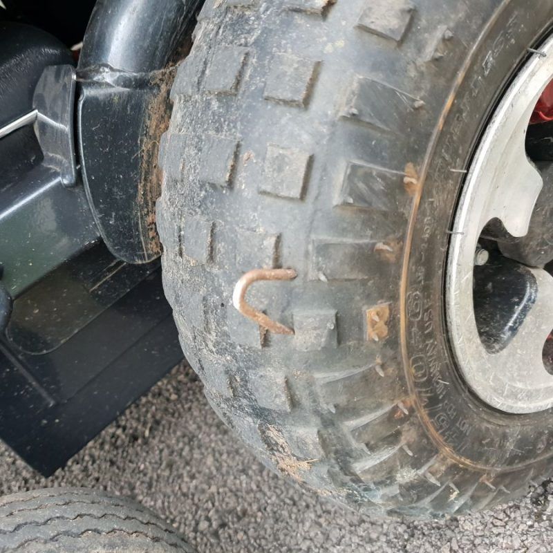A wheelchair tyre with a copper coloured hook sticking out of it