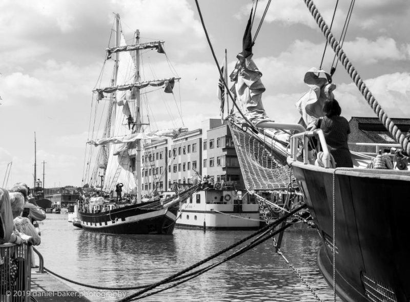 A black and white photo of a sailed tall ship entering Gloucester Docks