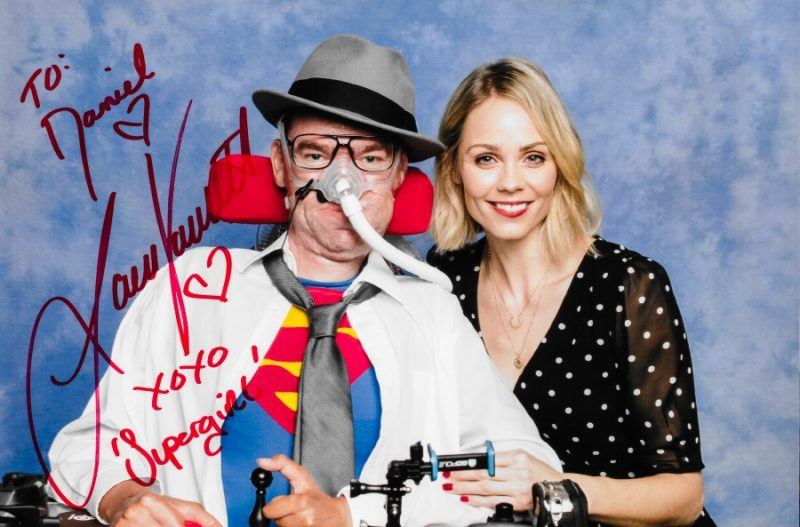 Collage of Daniel Baker at Collectormania 26 wearing a Superman/Clark Kent cosplay next to Laura Vandervoort, copyright Showmasters