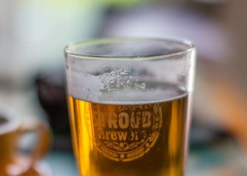 a close up photo of a pint of beer with Stroud Brewery written on the glass