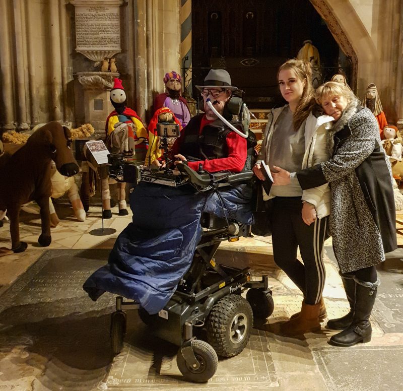 Daniel Baker with his Goddaughter and Mother in front of a knitted nativity scene at Gloucester Cathedral from Brief update for December 2019