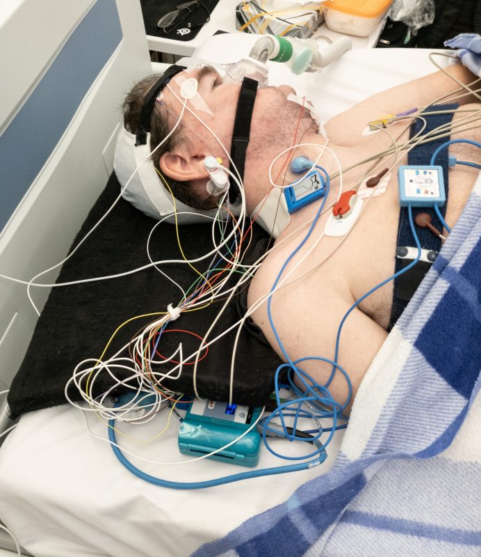 Daniel Baker in a hospital bed with lots of wires attached to him
