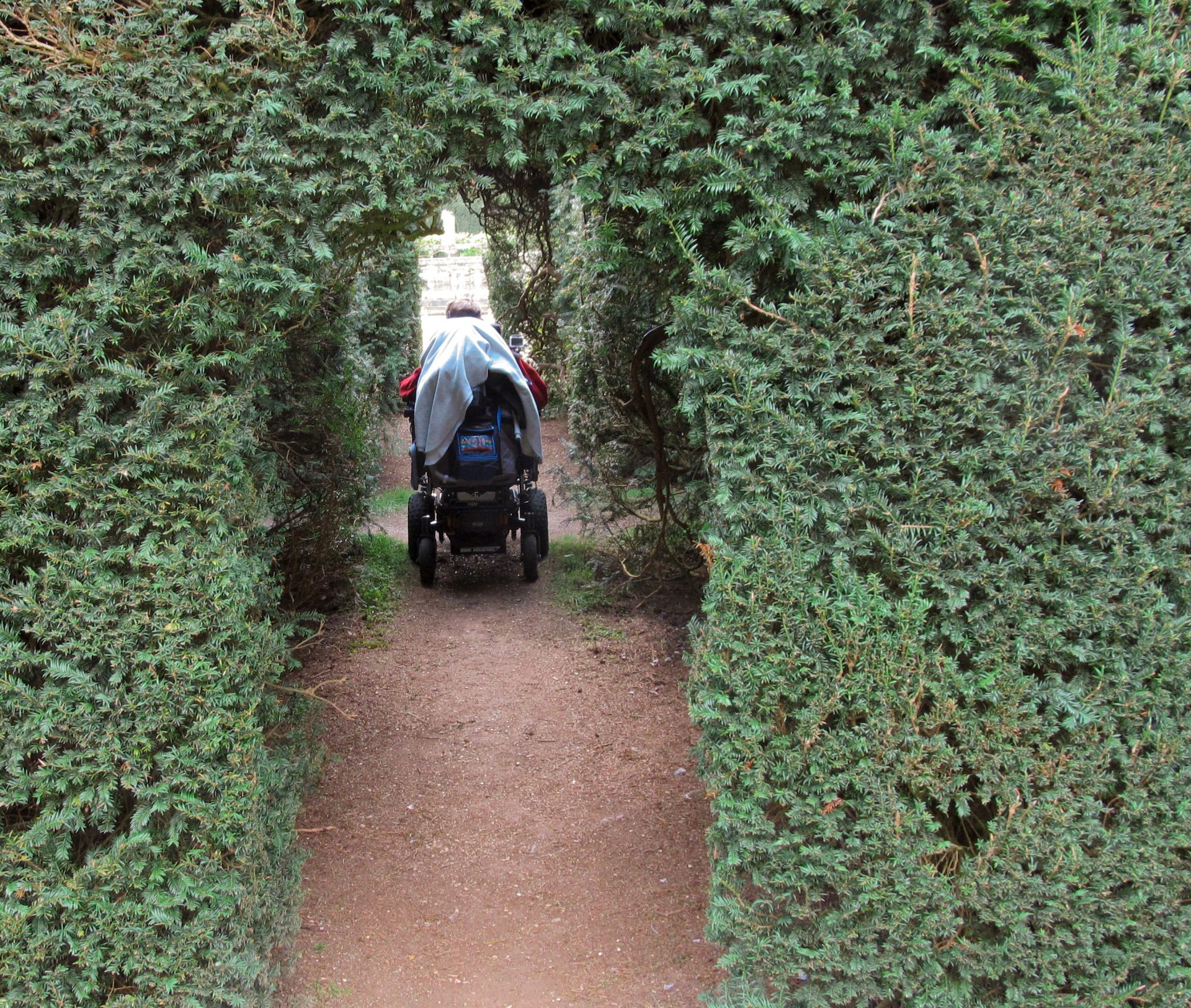 Daniel Baker in his wheelchair passing through archways cut in large hedges Looking Back to April 18th 2014 visit to Sudeley Castle