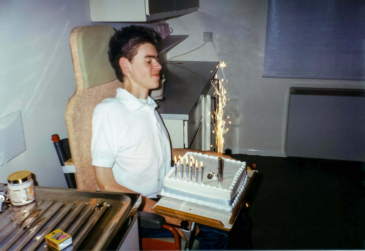 Daniel Baker sitting in a wheelchair with a birthday cake.