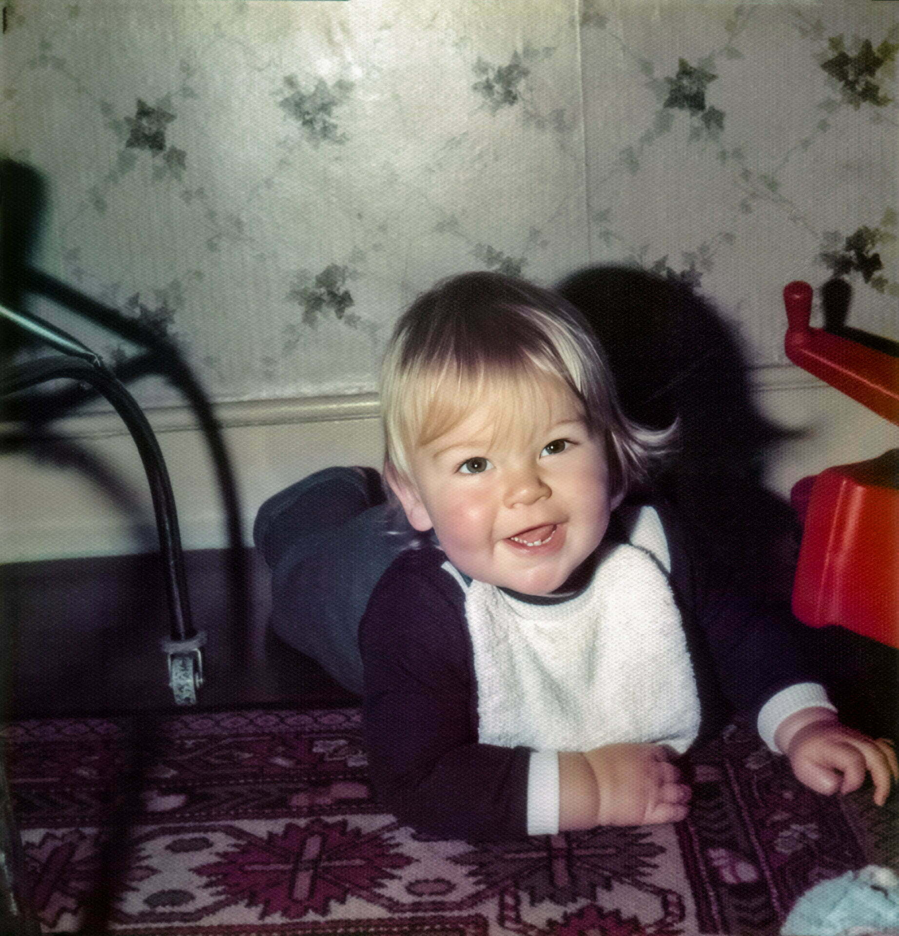 A very young Daniel Baker in a pram starting at the camera