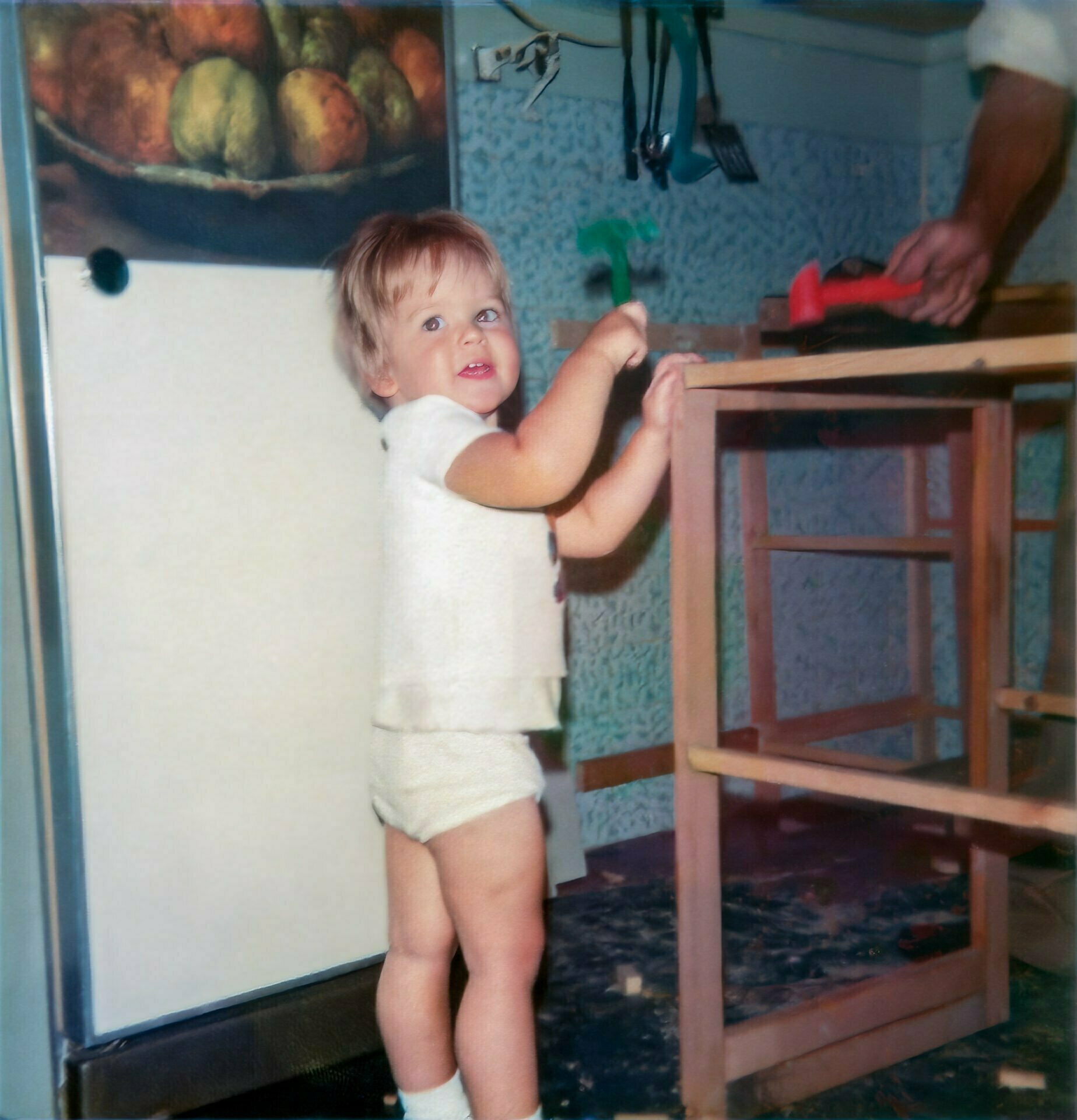 A very young Daniel Baker standing on tiptoe in a kitchen