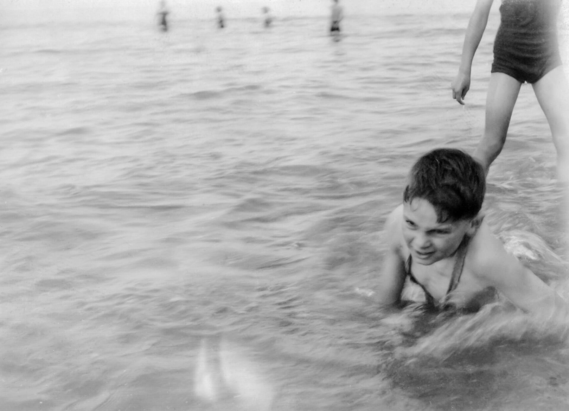 Black and white photo of a child playing in the sea