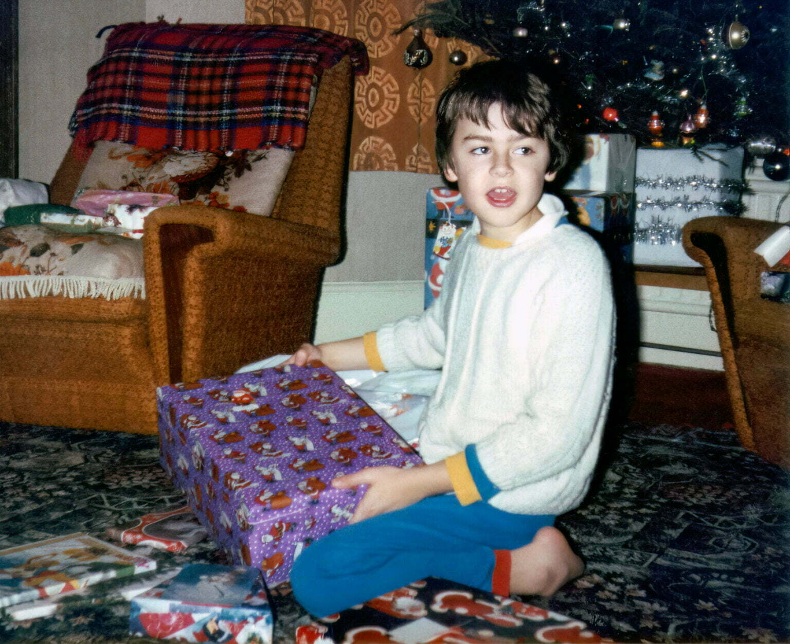 an old photo of Daniel Baker opening Christmas presents.