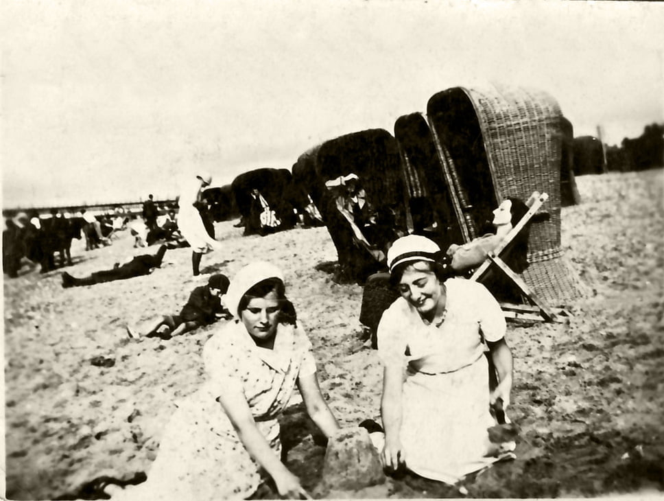 Black and white photo of two women sitting on a beach