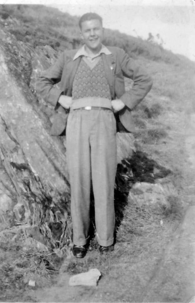 Black and white photo with a man standing with his hands on his hips